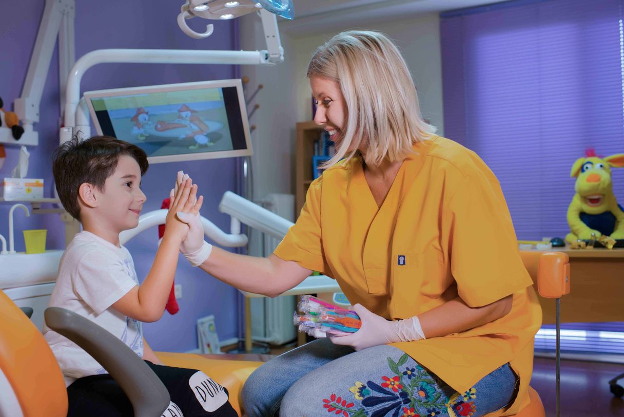 Η παιδοντίατρος Χριστίνα Παυλίδου κοιτάει χαρούμενη ένα παιδί κολλώντας τα χέρια τους στο αέρα